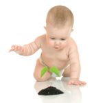 Small baby with green plant isolated